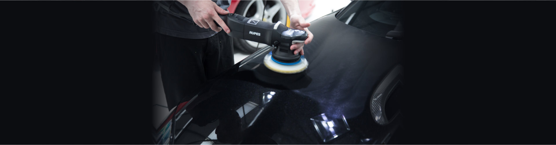 Detailer using a Rupes rotary machine on a luxury car. Automobile, swirl.
